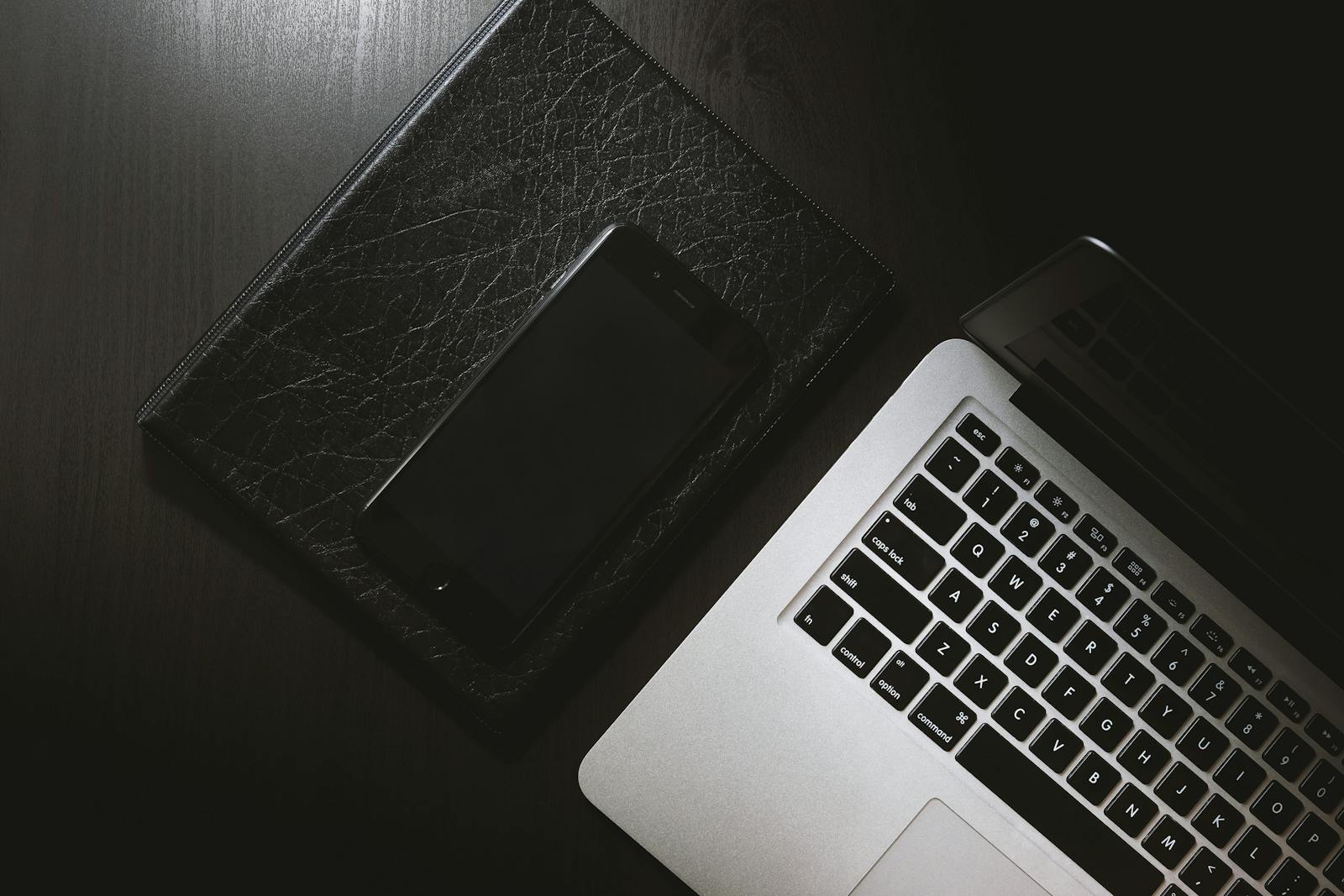 Smartphone and laptop on a desk used as article artwork.