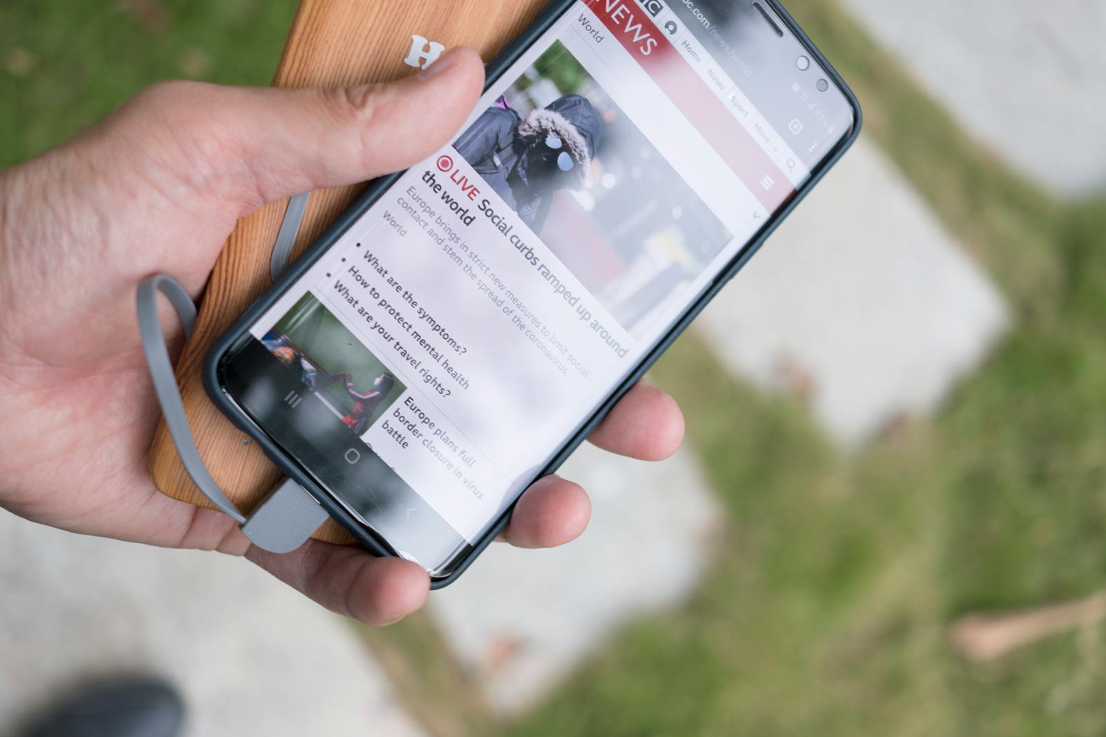 Black Android smartphone in hand used as article artwork.